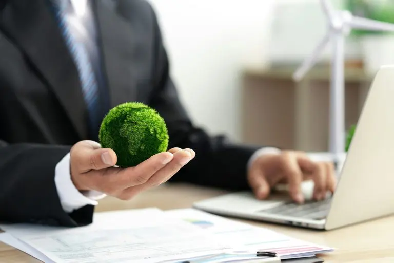 Businessman holds a green ball globe. ESG concept. Environmental, social and governance