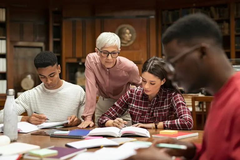 University students studying with teacher