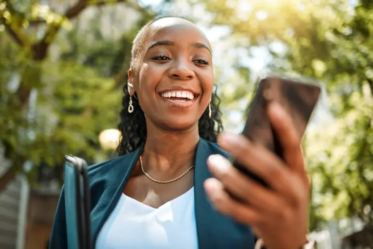 Happy black woman, phone and city for social media, communication or online browsing at the park. A